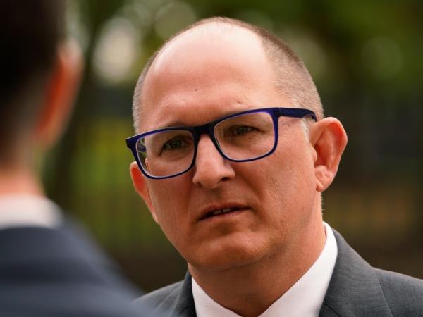 A balding middle aged man with glasses.